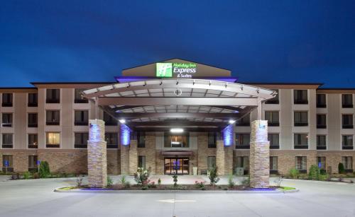a hotel exterior at night with a large building at Holiday Inn Express & Suites St Louis Airport by IHG in Woodson Terrace
