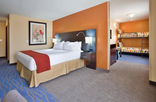 a hotel room with a large bed and a staircase at Holiday Inn Express & Suites St Louis Airport by IHG in Woodson Terrace