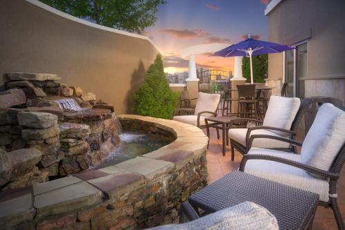 a patio with a pond and chairs and an umbrella at Holiday Inn Express Hotel & Suites Chattanooga Downtown by IHG in Chattanooga