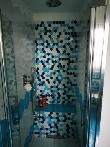 a bathroom with a shower with blue and white tiles at B&B Luna Nuova in Sarzana