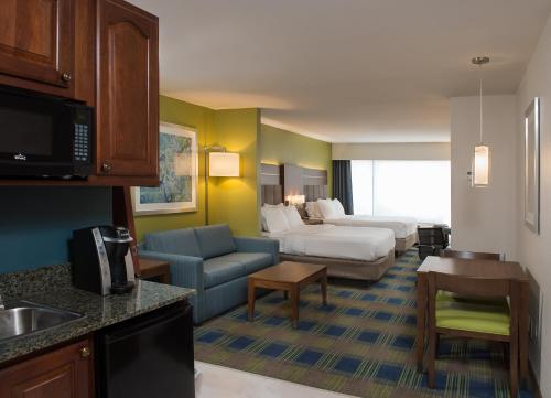 a hotel room with a bed and a living room at Holiday Inn Express Hotel & Suites Clifton Park, an IHG Hotel in Clifton Park