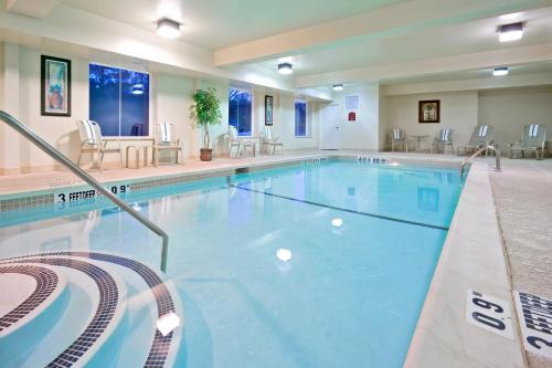 a pool at a hotel with chairs and tables at Holiday Inn Express Hotel & Suites Clifton Park by IHG in Clifton Park