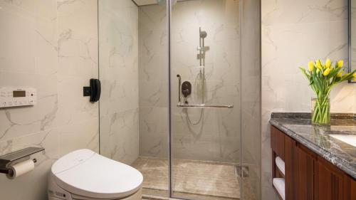 a bathroom with a shower with a toilet and a sink at Holiday Inn Suites Xi'an High-Tech Zone, an IHG Hotel in Xi'an