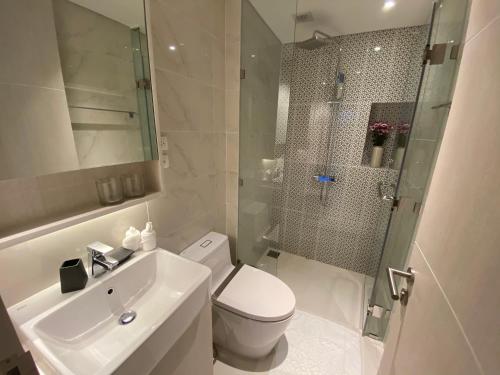 uma casa de banho com um WC, um chuveiro e um lavatório. em Cassia Apartment 1 em Praia de Bang Tao