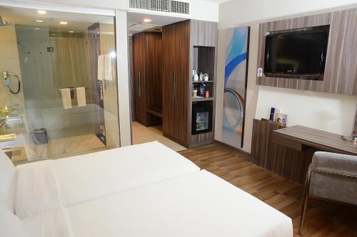 a hotel room with a bed and a television at Novotel Bangkok IMPACT in Nonthaburi