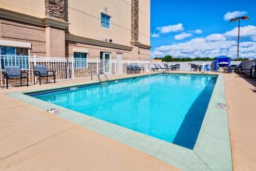 a swimming pool with chairs and a building at Holiday Inn Express & Suites Cookeville, an IHG Hotel in Cookeville