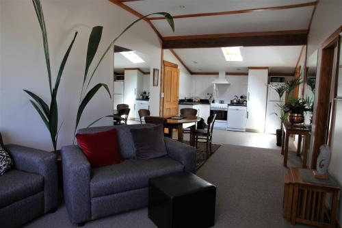 a living room with a couch and a table at Tarawhata Thermal Apartment in New Plymouth