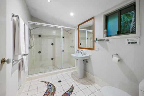 a white bathroom with a shower and a sink at Hunchy Hideaway in Montville