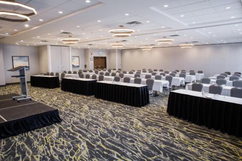 a conference room with tables and chairs and a podium at Holiday Inn Hotel & Suites Calgary South - Conference Ctr by IHG in Calgary