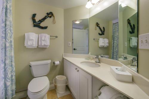 a bathroom with a toilet and a sink and a mirror at Holiday Inn Club Vacations South Beach Resort in Myrtle Beach