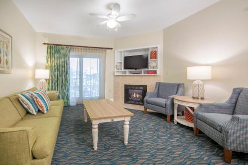 a living room with a couch and chairs and a fireplace at Holiday Inn Club Vacations South Beach Resort in Myrtle Beach