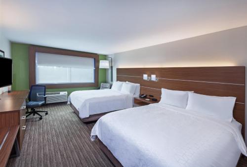 een hotelkamer met 2 bedden en een televisie bij Holiday Inn Express & Suites - Brenham South, an IHG Hotel in Brenham
