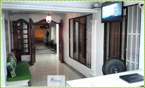 sala de estar con TV en la pared en HOTEL CASA GARCES, en Cartagena de Indias
