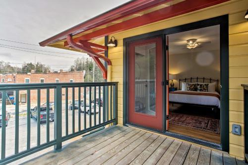 a balcony with a red door on a yellow house at Walk to Dining Saluda Main Street Retreat! in Saluda