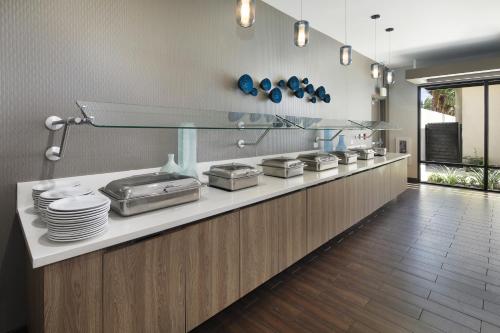 eine Küche mit einer Theke mit Tellern und Geschirr in der Unterkunft Holiday Inn Hotel & Suites Anaheim by IHG in Anaheim