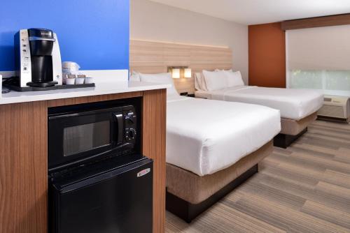 a hotel room with two beds and a television at Holiday Inn Express Hotel & Suites Cincinnati - Mason by IHG in Mason