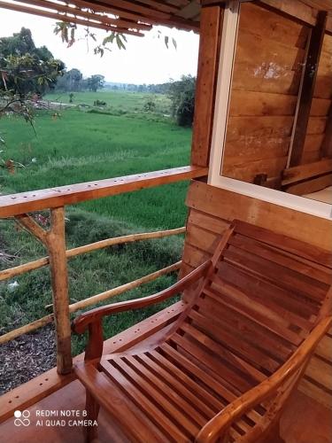 a bench in a porch with a view of a field at Wilpattu Green Cabin in Achchamulai