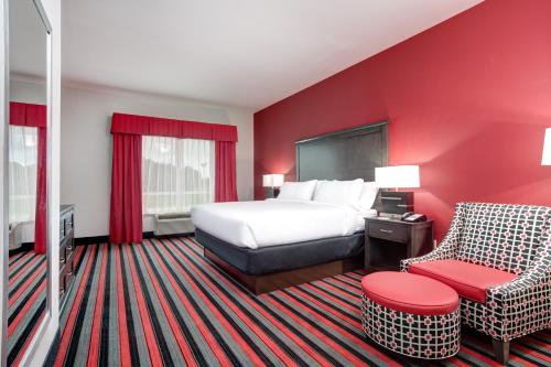 a hotel room with a bed and a chair at Holiday Inn Lafayette North by IHG in Lafayette