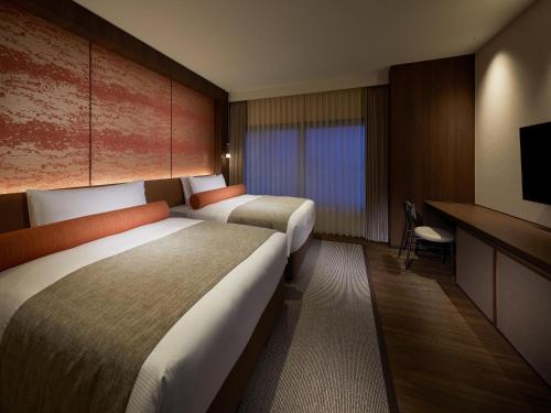 Ένα ή περισσότερα κρεβάτια σε δωμάτιο στο Okinawa NaHaNa Hotel & Spa