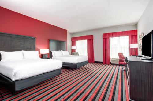 a hotel room with two beds and a flat screen tv at Holiday Inn Lafayette North by IHG in Lafayette