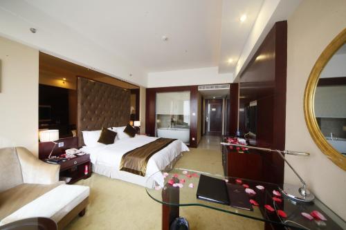 a hotel room with a bed and a mirror at Foshan Royal Prince Hotel in Shunde