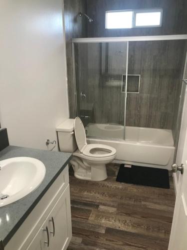 a bathroom with a toilet and a tub and a sink at A1 LA City Hostel in Los Angeles