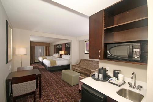 a hotel room with a bed and a bathroom at Holiday Inn Express & Suites Charlotte North, an IHG Hotel in Charlotte