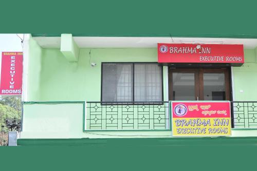 un bâtiment avec des panneaux sur son côté dans l'établissement Brahma Inn, à Bangalore