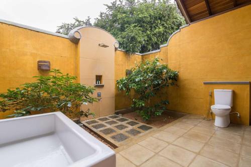 a bathroom with a bath tub and a toilet at Kumbukgaha Villa in Sigiriya