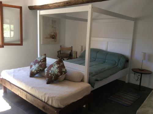 a bedroom with a canopy bed with a couch at Casa Cleo - Somente carro 4x4 ou fazemos translado sem custo in São Francisco Xavier
