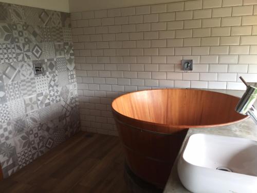 a bathroom with a wooden tub next to a sink at Casa Cleo - Somente carro 4x4 ou fazemos translado sem custo in São Francisco Xavier
