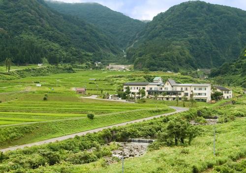 糸魚川市にある笹倉温泉 龍雲荘  の山を背景に見える農場