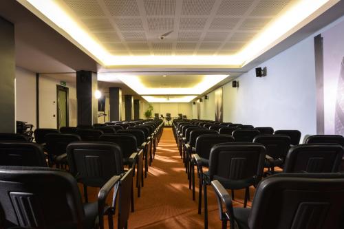 an empty room with rows of chairs and lights at Best Western Plus Hotel Expo in Villafranca di Verona