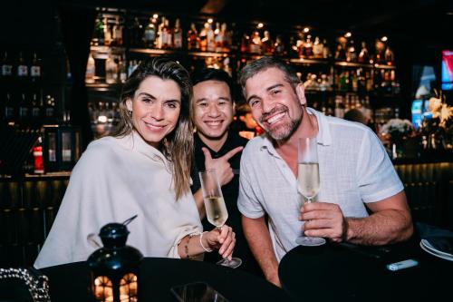 three people holding champagne glasses in a bar at La Sinfonía Majesty Hotel and Spa in Hanoi