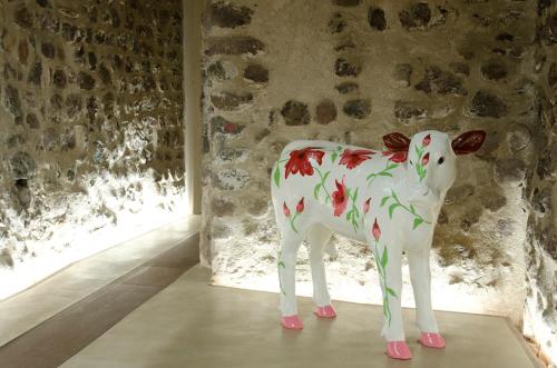 a statue of a cow in a room with a window at Stay COOPER l Goethe Guesthouse in Bolzano