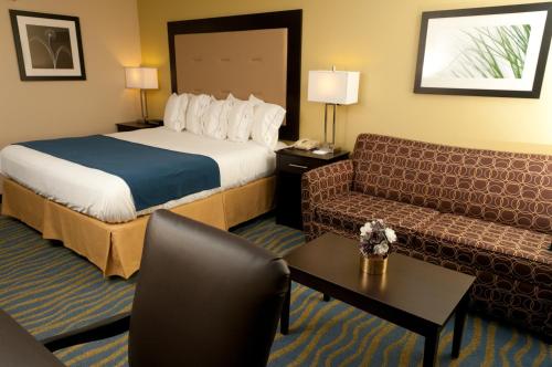a hotel room with a bed and a couch at Holiday Inn Express Hotel & Suites Bloomington-Normal University Area by IHG in Bloomington