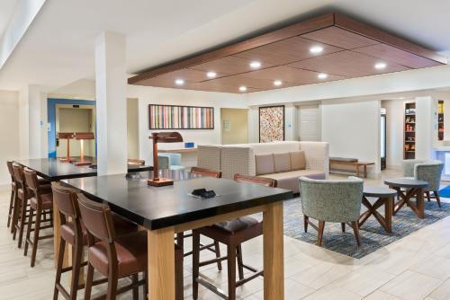 a living room with a large table and chairs at Holiday Inn Express & Suites - Columbus Airport East by IHG in Columbus
