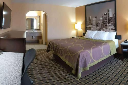 a hotel room with a bed and a sink at Super 8 by Wyndham Houston/Willowbrook Hwy 249 in Houston