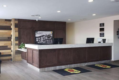 a lobby with a reception counter with mats on the floor at Super 8 by Wyndham Spruce Grove in Spruce Grove