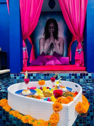 a woman sitting on a bed in a tub with flowers at Villa Majorelle Bali in Seminyak