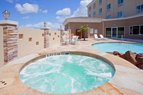 a swimming pool on a patio next to a building at Holiday Inn Express Houston Space Center-Clear Lake, an IHG Hotel in Webster