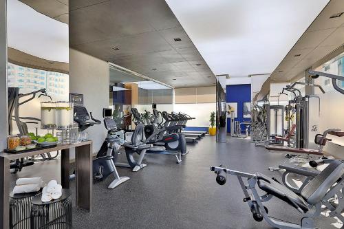 a gym with a lot of treadmills and machines at voco Dubai by IHG in Dubai