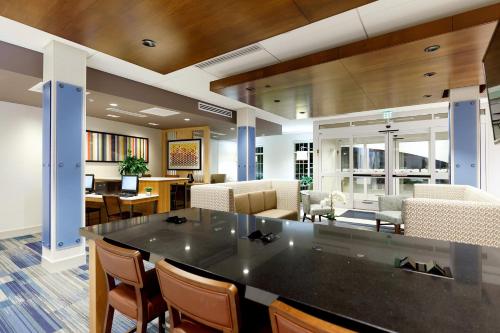 an office lobby with a large black counter and chairs at Holiday Inn Express & Suites - Sturbridge by IHG in Sturbridge