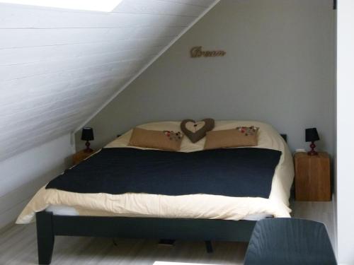 a bed with two pillows on it in a attic at Espace Bien Etre et Spa in Libin