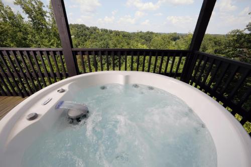a jacuzzi tub on a deck with a view at Three-Bedroom Apartment in Pigeon Forge