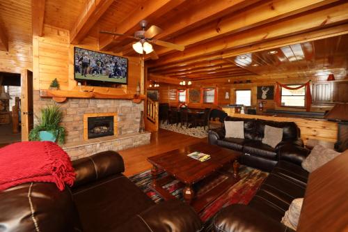 a living room with leather furniture and a fireplace at Ridgetop Theatre Lodge Cabin in Park Settlement