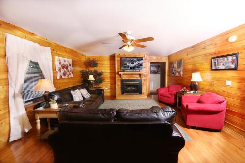 a living room with a leather couch and red chairs at Three-Bedroom Apartment in Pigeon Forge