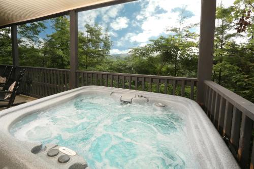a jacuzzi tub on a deck with a view at Three-Bedroom Apartment in Pigeon Forge