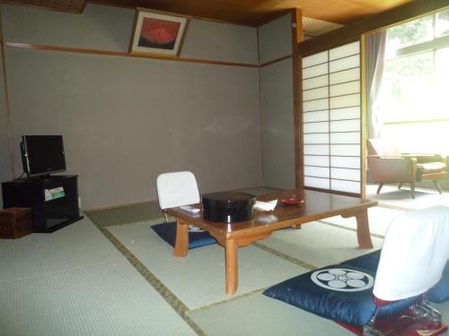 a living room with a table and chairs at Takao Kanko Hotel in Kyoto
