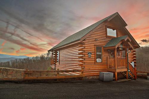 a log cabin with a sunset in the background at Howling Wolf in Sevierville